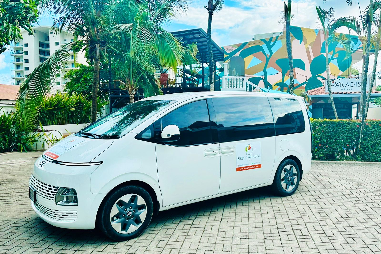 A private transfer van waiting outside the hotel