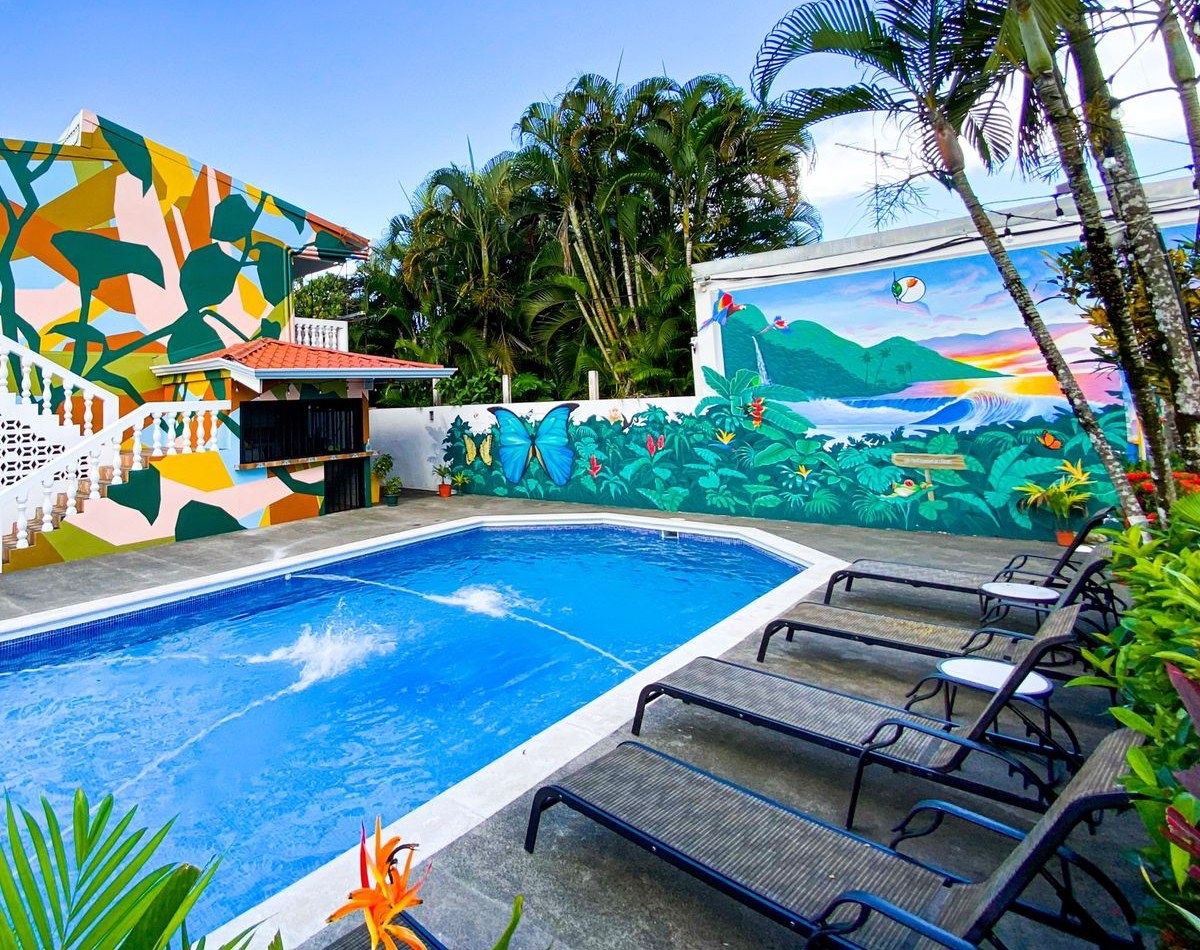 La piscina y las paredes pintadas del patio de Bird of Paradise Hotel